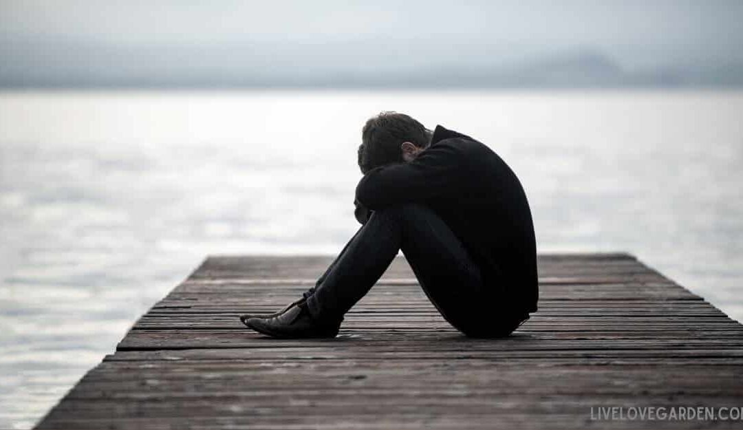 How to Heal After a Breakup and Move Forward Man sad sitting on dock at lake