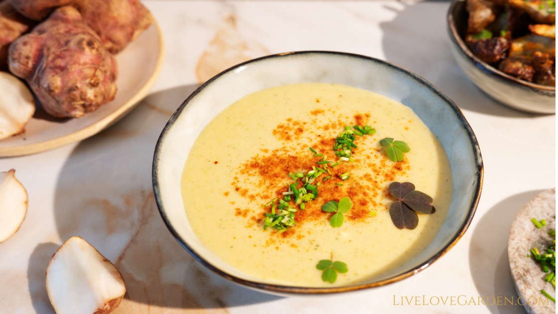 Creamy sunchoke soup in a bowl with fresh tarragon garnish.